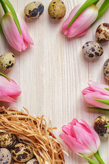 Fototapeta na wymiar Easter background pink tulips on wooden table, quail eggs, nest.