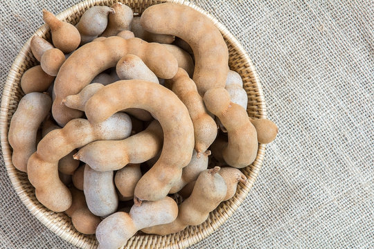 Tamarinds in rattan basket on burlap background