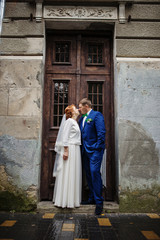 Naklejka premium Wedding couple in love background old vintage wooden doors.