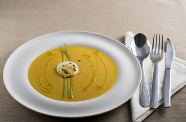 cream of pumpkin soup with boiled egg and chives pepper