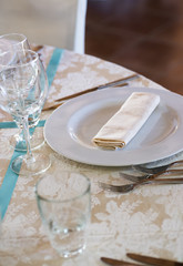 silverware and cutlery sets and glasses on a linen tablecloth