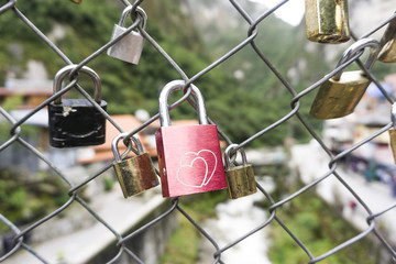 Red heart shaped lock padlock on the fence on the background