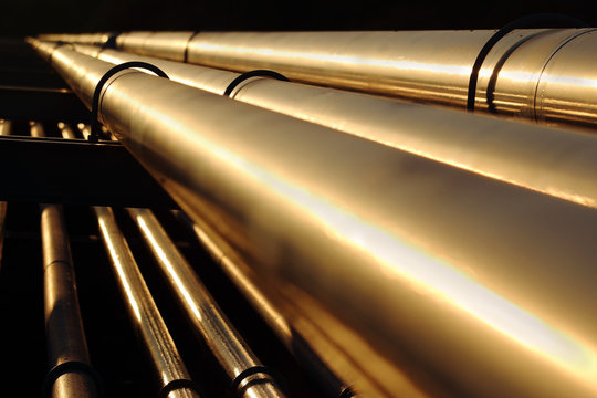 golden steel pipes in oil refinery during sunset