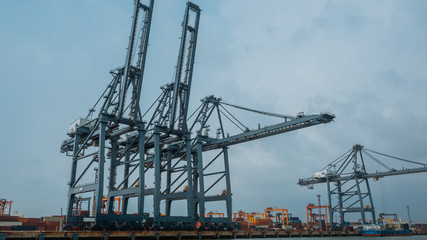 Fototapeta na wymiar Large dockside gantry steel crane lifting a containers at the port of Laem Chabang in Chonburi Province, Thailand in vintage style image.