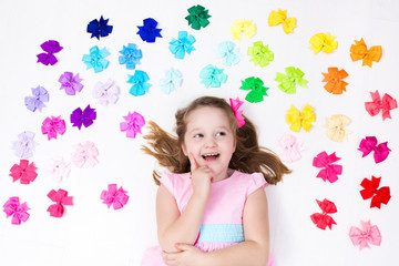 Fototapeta na wymiar Little girl with colorful bow. Hair accessory