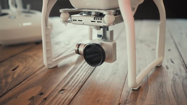 Close focus on drone 4k camera with mounted nd8 filter. Power turned on and camera starts moving to initialize itself, leds blink