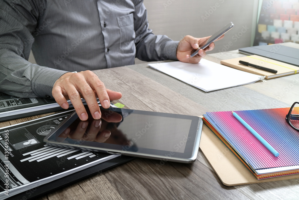 Aufkleber website designer holding smart phone and working computer digital tablet on wood table