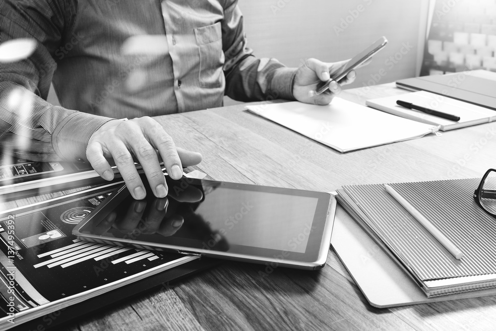 Aufkleber Website designer holding smart phone and working computer digital tablet on wood table