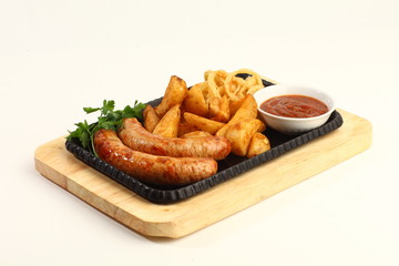 Fried sausages with fried potatoes. Served on a wooden Board with tomato sauce. Horizontal image.
