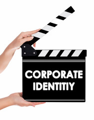 Obraz premium Hands holding a clapper board with CORPORATE IDENTITIY text