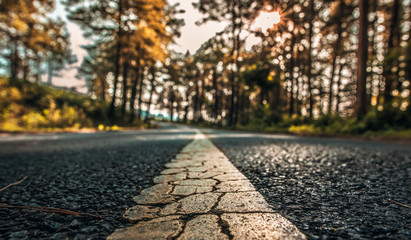 Yellow line rough surface and grey cracked asphalt road texture in vintage style.