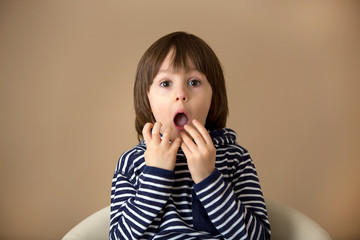 Sweet preschool boy, making faces with different emotion