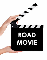 Obraz premium Hands holding a clapper board with ROAD MOVIE text