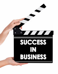 Obraz premium Hands holding a clapper board with SUCCESS IN BUSSINESS text