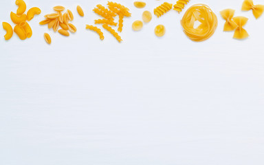 Italian foods concept and menu design. Various kind of Pasta Farfalle, Pasta A Riso, Orecchiette Pugliesi, Gnocco Sardo and Farfalle  setup on white wooden background with flat lay.