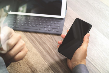 Hand using mobile payments online shopping,omni channel,icon customer network,in modern office wooden desk, blank interface screen,filter effect