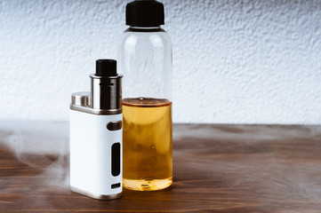 Electronic cigarette and a bottle of liquid on the table