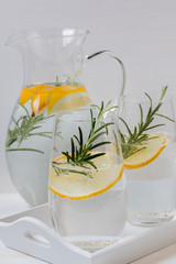 Fresh water drink with lemon,rosemary and cucumber. White background.