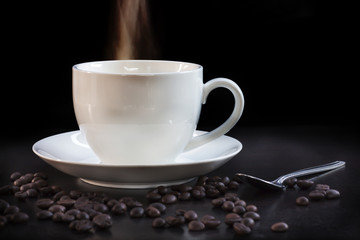 Hot cup of coffee in white on a dark background.