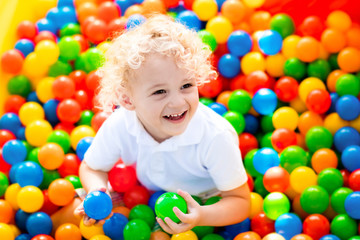 Fototapeta na wymiar Child playing in ball pit on indoor playground