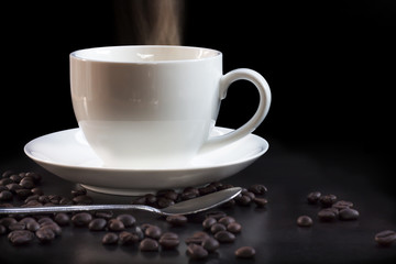 Hot cup of coffee in white on a dark background.