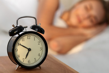 Beautiful young woman sleeping and smiling while lying in bed comfortably and blissfully on the...