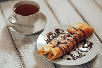 Delicious breakfast. Homemade Pancakes or blini with chocolate cream and cup 