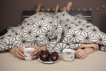Happy young couple eating breakfast in bed . - obrazy, fototapety, plakaty