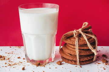 Transparent glass of milk and cookies on a white background