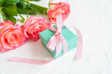 gift and three roses on white background