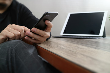 businessman hand using smart phone,mobile payments online shopping,omni channel,digital tablet docking keyboard computer in modern office on wooden desk