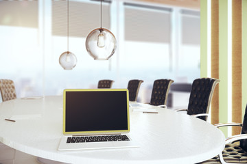 Conference table with blank laptop