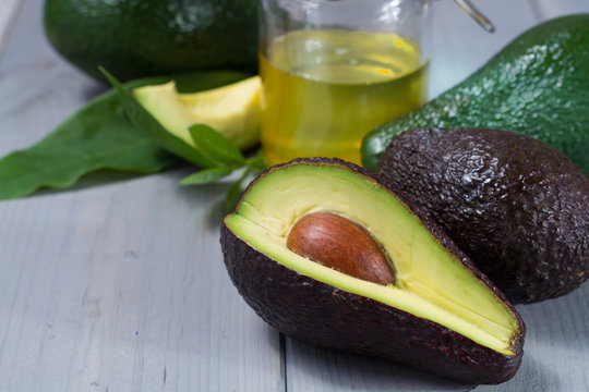 Green ripe avocado with leaves and organic avocado oil