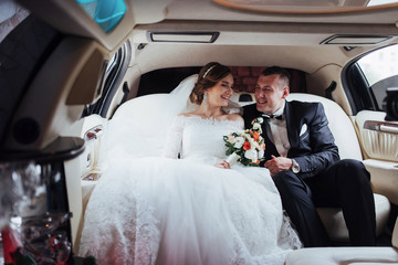 young couple in a car in wedding day.