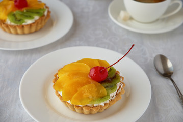 Tartlets with cream and fruit. Cherry, peach and kiwi.