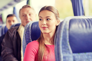 happy young woman sitting in travel bus or train