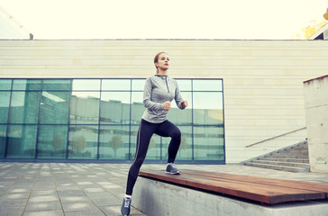 Fototapeta na wymiar woman making step exercise on city street bench