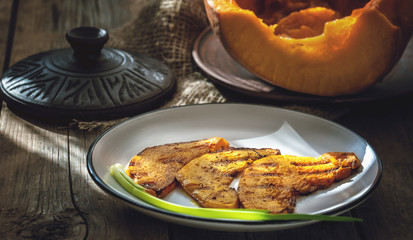 Slices of juicy orange pumpkin with spices, fried on the grill pan