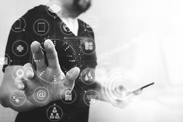 Designer hand pressing an imaginary button,holding smart phone,virtual digital screen graphic icons,graph,diagram interface computer,black and white