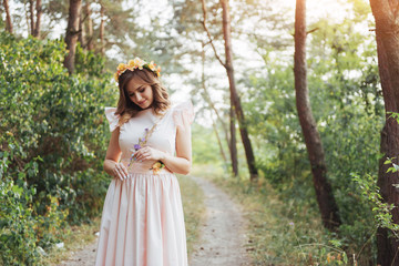 Happy young woman in long dress a beautiful pine forest