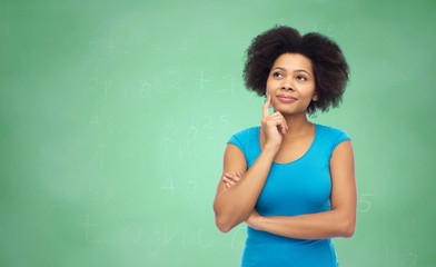 pensive afro american  woman over green chalkboard