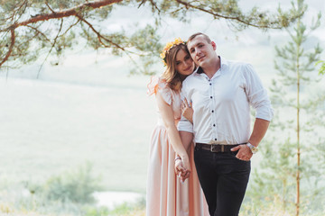 Happy young couple in a pine forest in summer