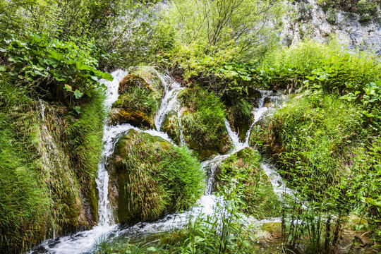 Cascades waterfalls, among the green grass. Plitvice, National Park, Croatia