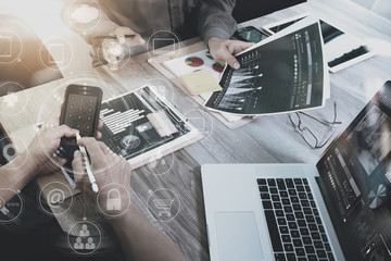 Designer Businessman hand using smart phone,mobile payments online shopping,omni channel,digital tablet docking keyboard computer in modern office on wooden desk,virtual interface icons screen