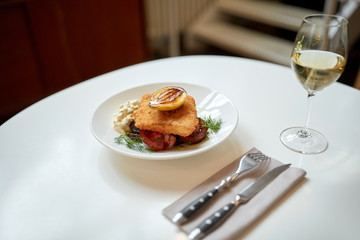 fish salad and wine glass on restaurant table 