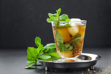 Mint Julep cocktail with bourbon, ice and mint in glass on black background - obrazy, fototapety, plakaty
