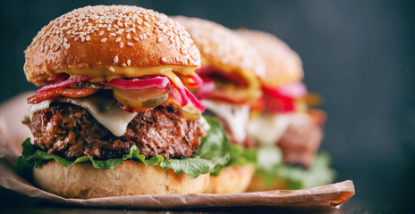 a delicious and juicy burger home in a rustic style with a big chop of beef - obrazy, fototapety, plakaty