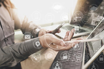 Designer Businessman hand using smart phone,mobile payments online shopping,omni channel,digital tablet docking keyboard computer in modern office on wooden desk,virtual interface icons screen