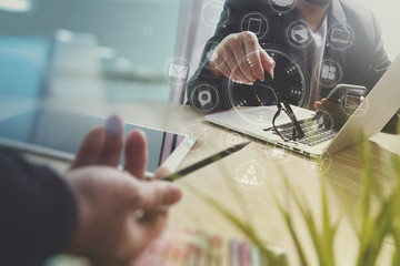 Designer Businessman hand using smart phone,mobile payments online shopping,omni channel,digital tablet docking keyboard computer in modern office on wooden desk,virtual interface icons screen