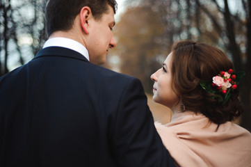 Couple walks in the park. Romantic embrace of newlyweds.